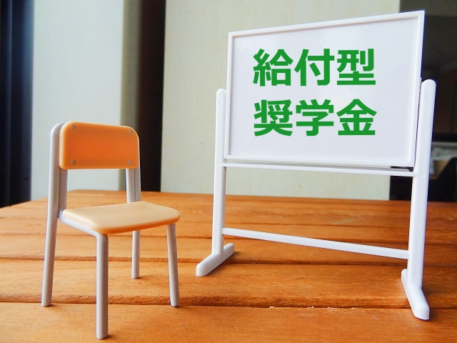 「給付型奨学金」と書かれたホワイトボードとミニチュアの椅子