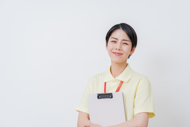 クリップボードを持つ笑顔の女性スタッフ