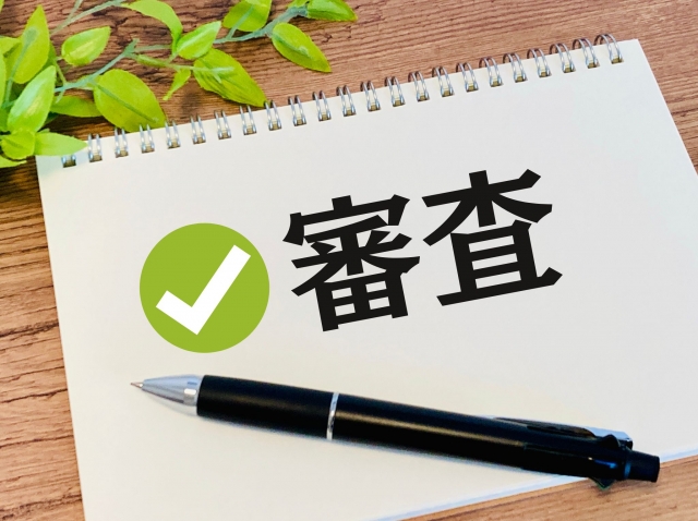 給付型奨学金の審査通過を示すノートとチェックマーク