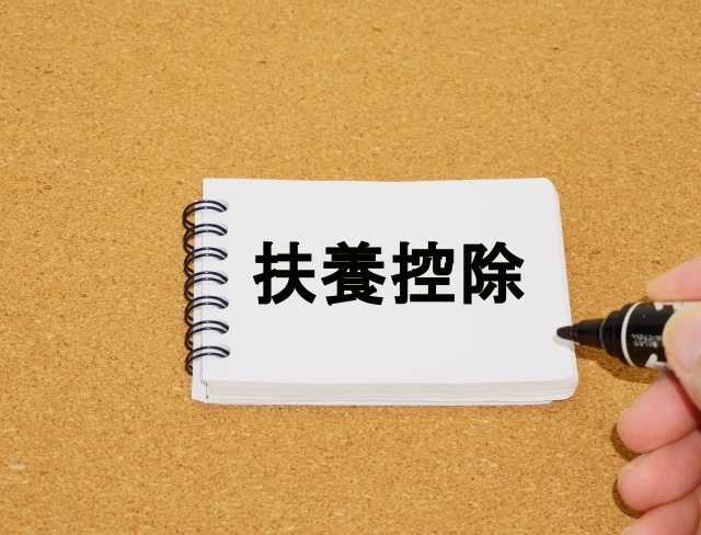 扶養控除と書かれたノートとペンの写真