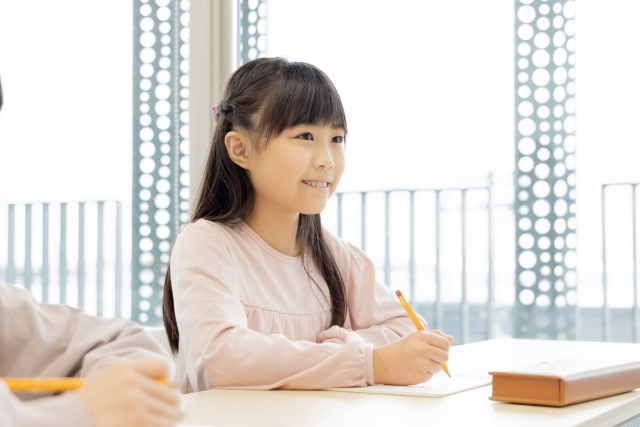 母子家庭の子どもが学習塾で勉強している様子。補助金を活用して安心して通塾しているイメージ。